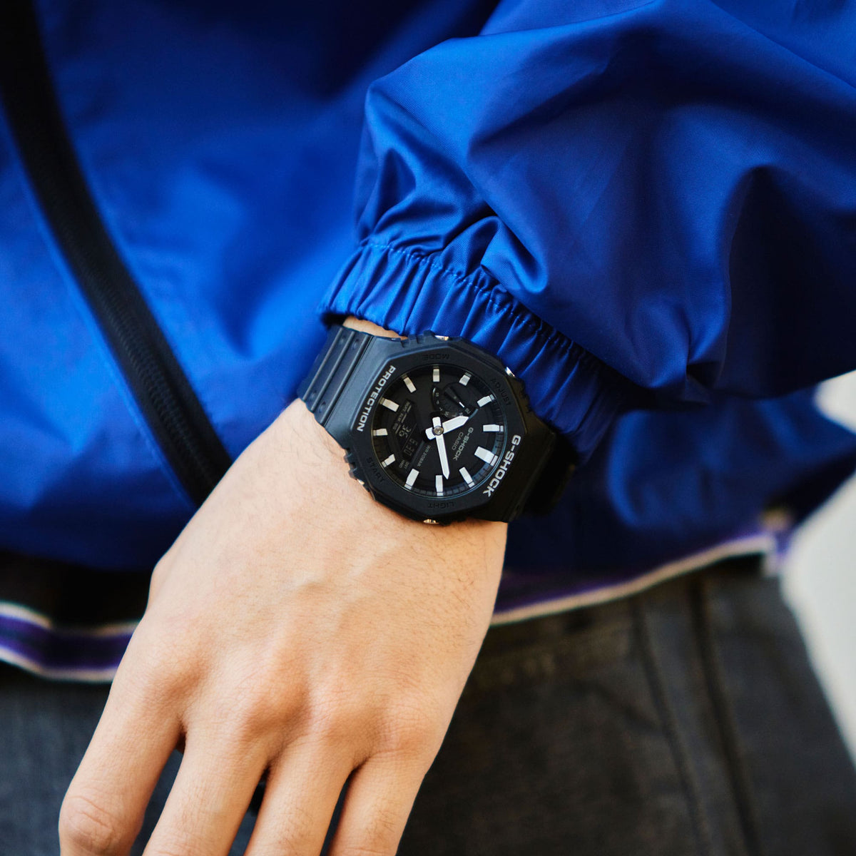 G-Shock CasiOak GA-2100 in black worn on the wrist with a blue jacket