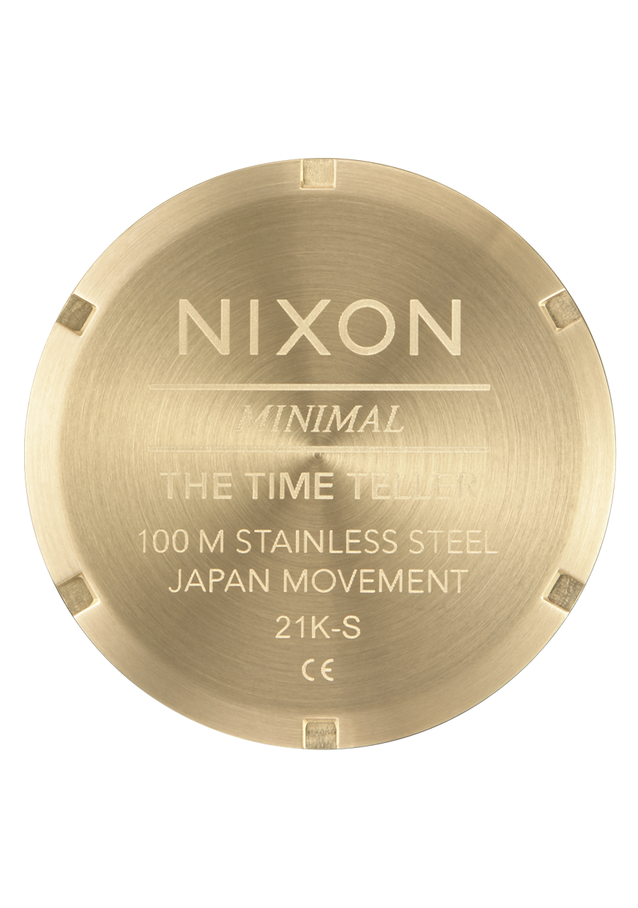 Circular gold-colored watch caseback with engraved text detailing the brand and specifications.