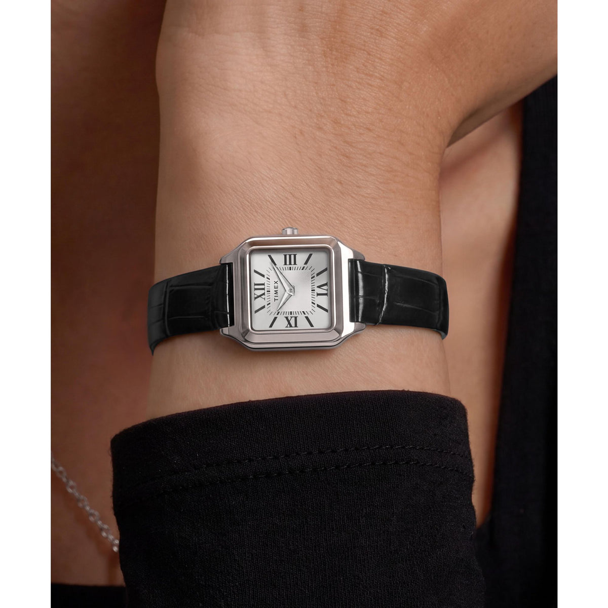 Timex Addison TW2Y90600 silver dial with Roman numerals on a black leather strap, worn on the wrist