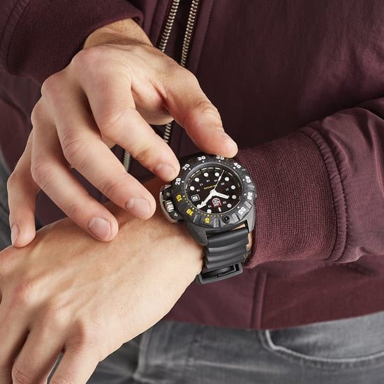 Rugged sports watch with a black dial and multiple functions worn on a person’s wrist.