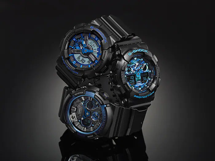 Three black G-Shock watches with blue accents displayed together.