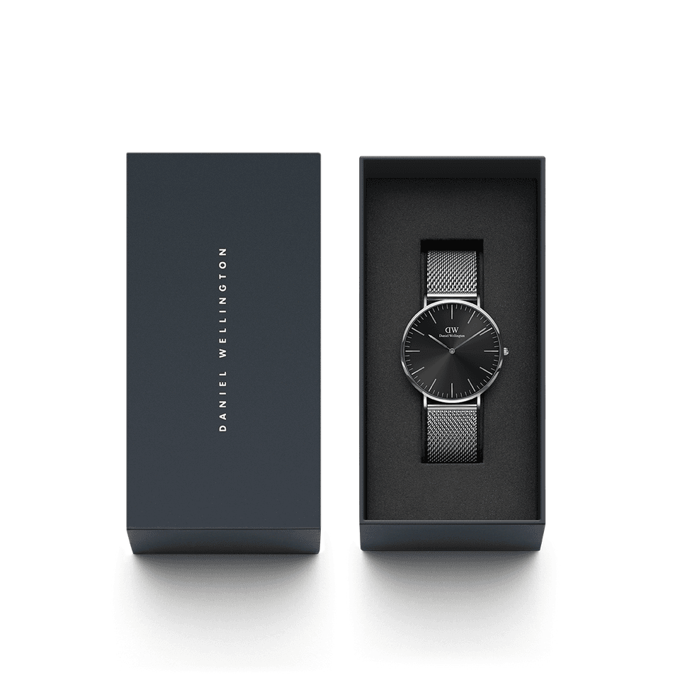 Sleek black wristwatch with a mesh metal band displayed in an open gift box.