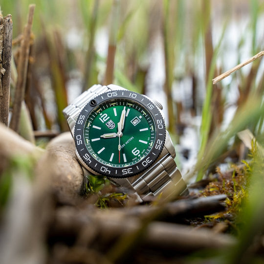 Wristwatch with a green dial and silver metal bracelet.