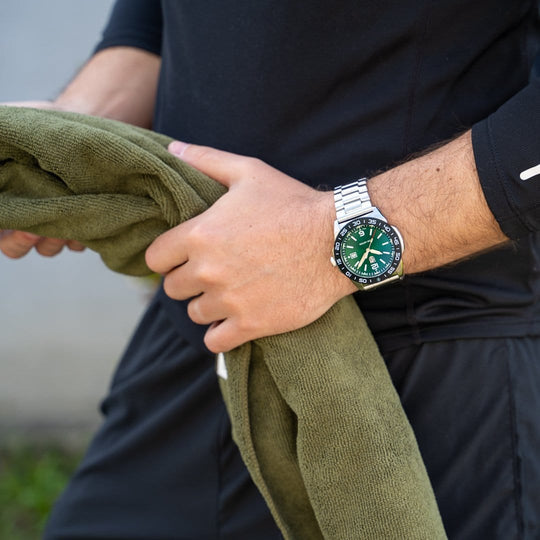 Wristwatch with a green dial and silver metal bracelet.
