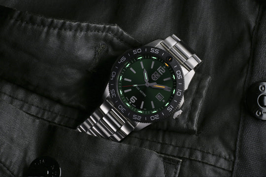 Stainless steel wristwatch with a green dial and metallic bracelet.