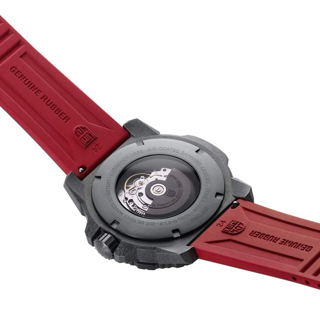 Wristwatch with a red rubber strap and black case showing its mechanical movement through the transparent back.