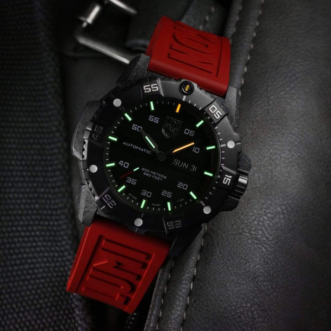 Rugged wristwatch with a black face and bright red rubber strap.
