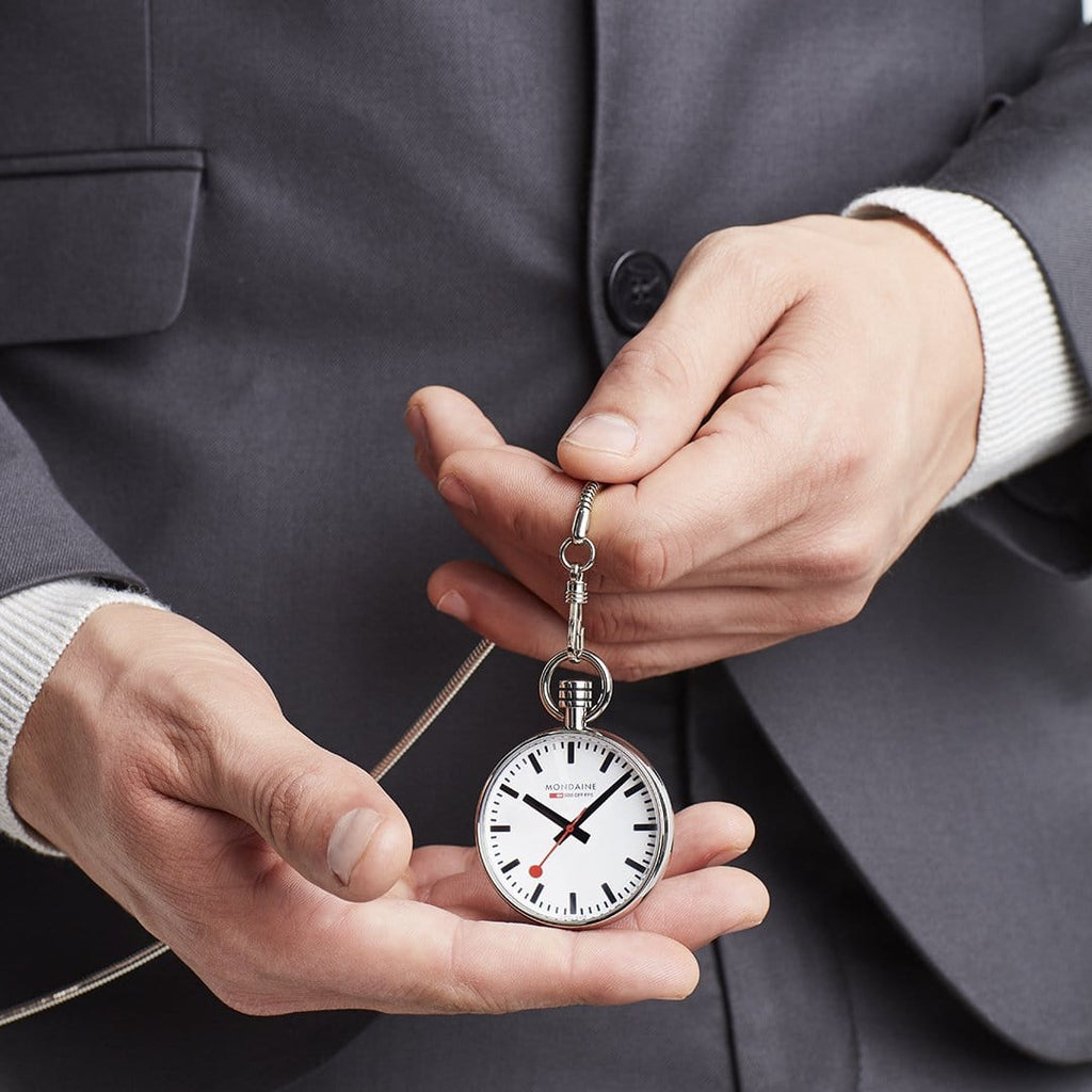 Pocket watch held in a person’s hands.