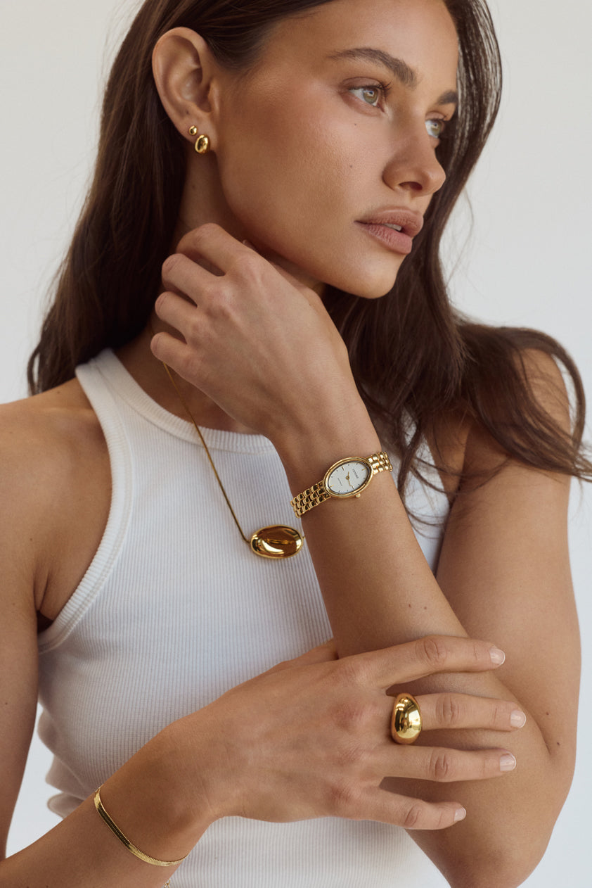 Cendré Bean gold earrings styled on a model