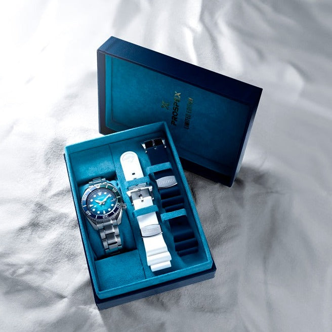 Luxury wristwatch with interchangeable straps in a presentation box.