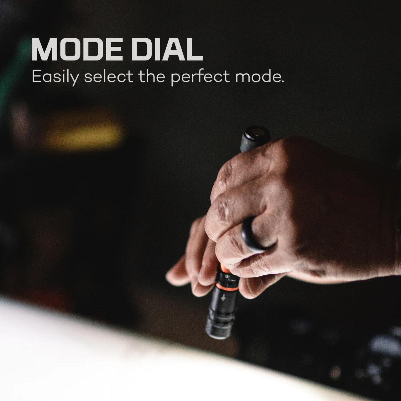 Hand turning a mode dial on a camera or electronic device.