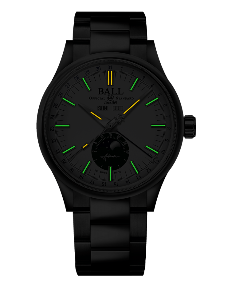 Black wristwatch with luminous green hour markers and a yellow 12 o’clock indicator.