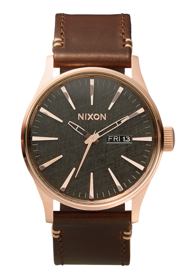 Wristwatch with a rose gold case, dark green dial, and brown leather strap.