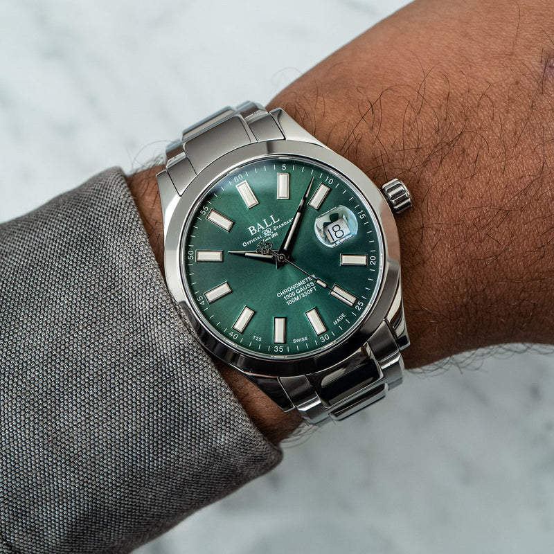 Stainless steel wristwatch with a green dial and date window.