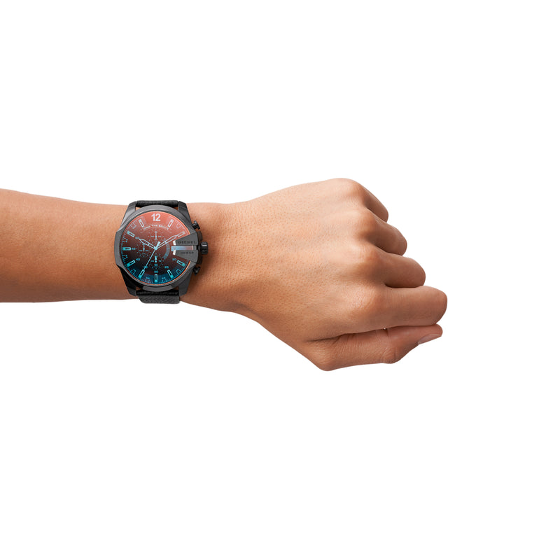 Wristwatch with a colorful analog face and dark band worn on a person’s wrist.