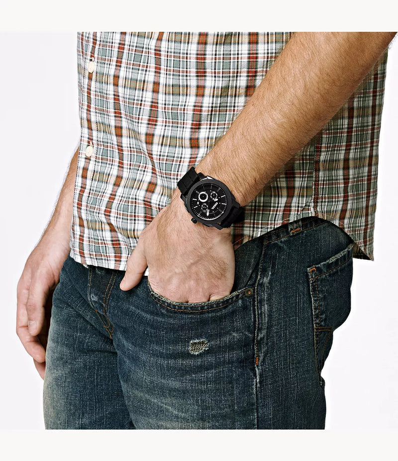 Black wristwatch with a round face worn on a person’s wrist.