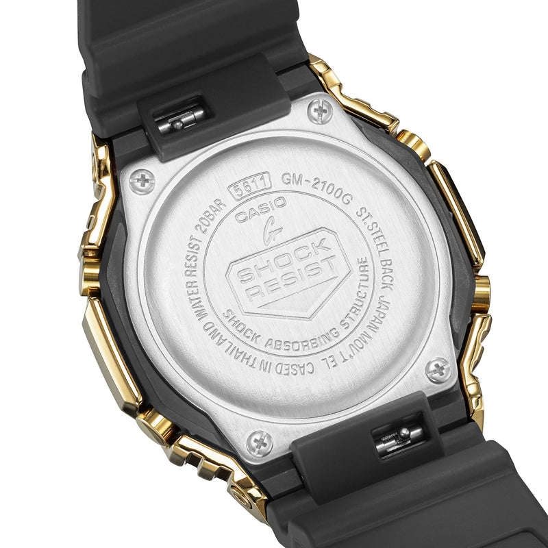 Back of a Casio G-Shock wristwatch with gold accents and a black rubber strap.