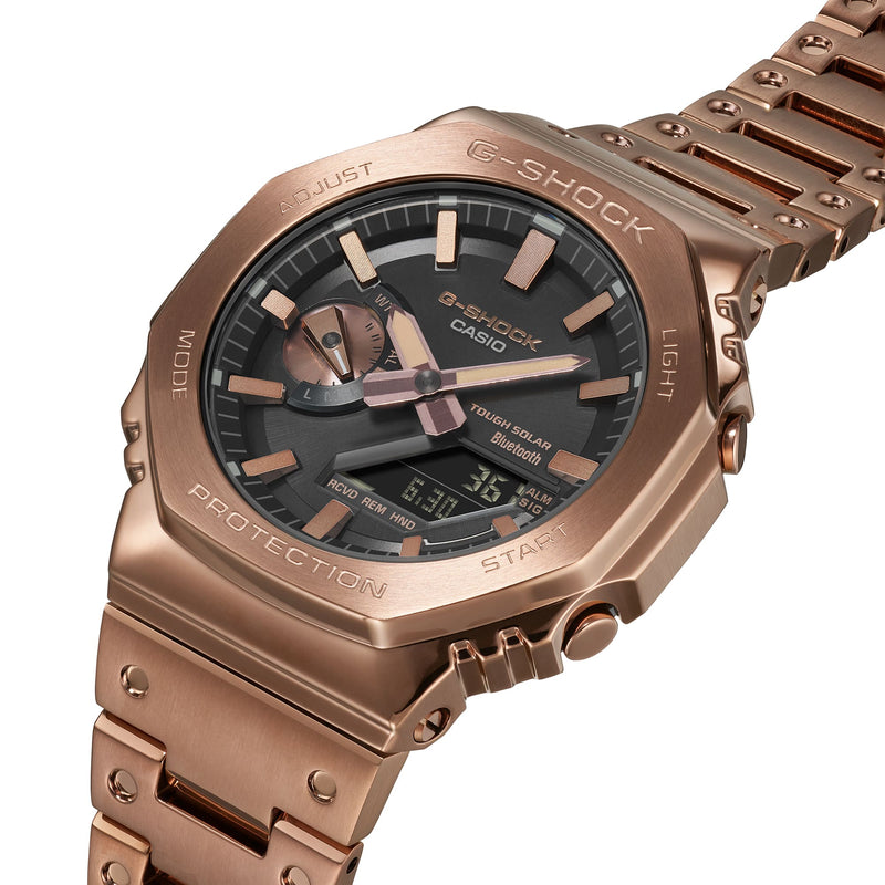 Rose gold G-Shock wristwatch with a metallic bracelet and analog-digital display.