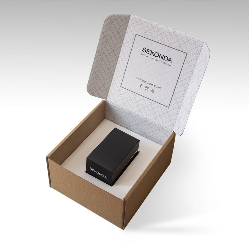 Open box containing a small black rectangular object, likely a product or device, with ’SEKONDA’ branding visible on the box lid.