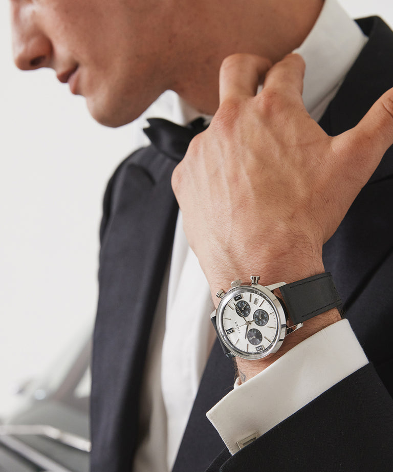 Elegant wristwatch with a white face and black leather strap.
