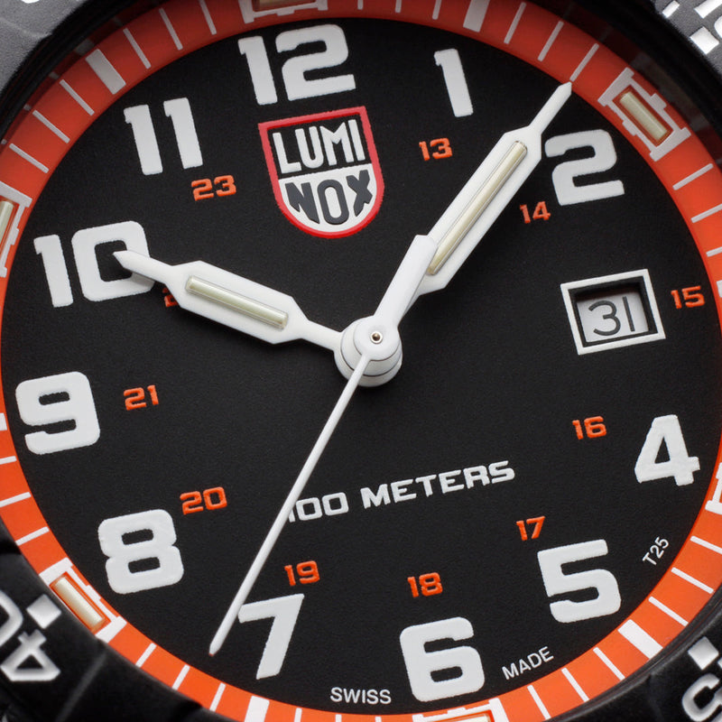 Luminox wristwatch face with orange and white markings on a black dial.