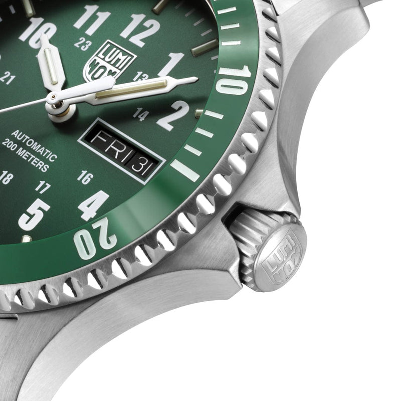 Luxury wristwatch with a green dial and silver case.