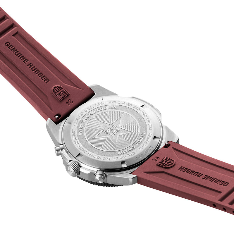 Wristwatch with a burgundy rubber strap and silver-toned case, showing the back of the watch face.