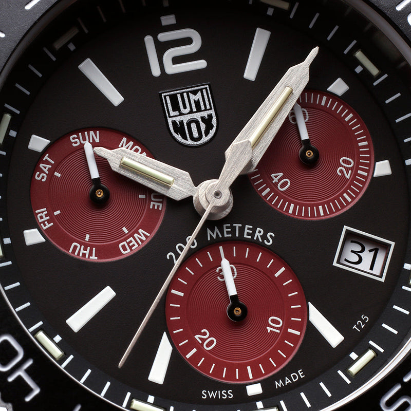 Luminox wristwatch face with black dial and red subdials showing chronograph functions.