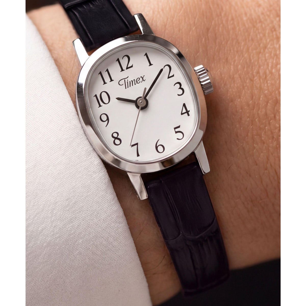 Timex Cavatina Mini TW2Y87800 white dial on a black leather strap, worn on the wrist