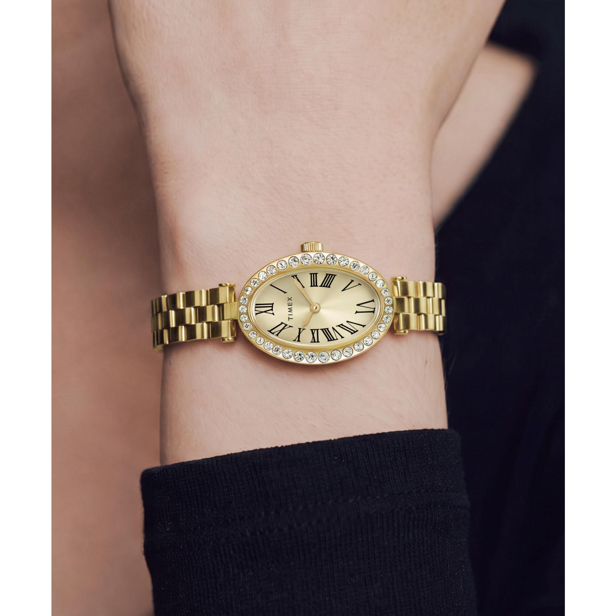 Timex Cavatina TW2Y90100 champagne dial with crystal-set bezel on a gold-tone bracelet, worn on the wrist