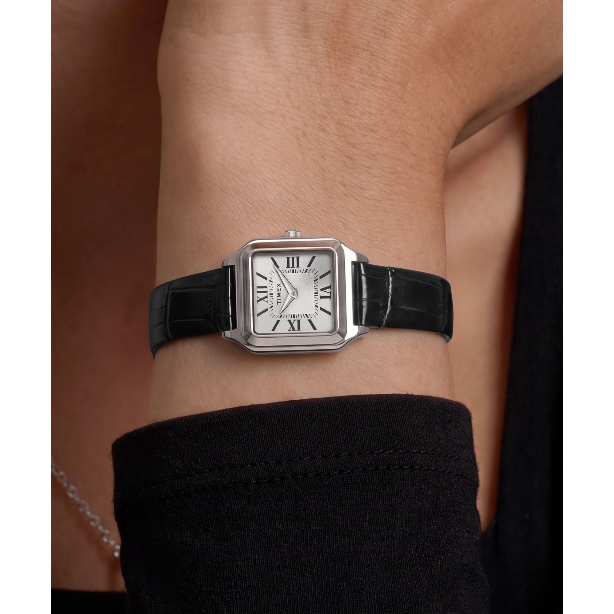 Timex Addison TW2Y90600 silver dial with Roman numerals on a black leather strap, worn on the wrist