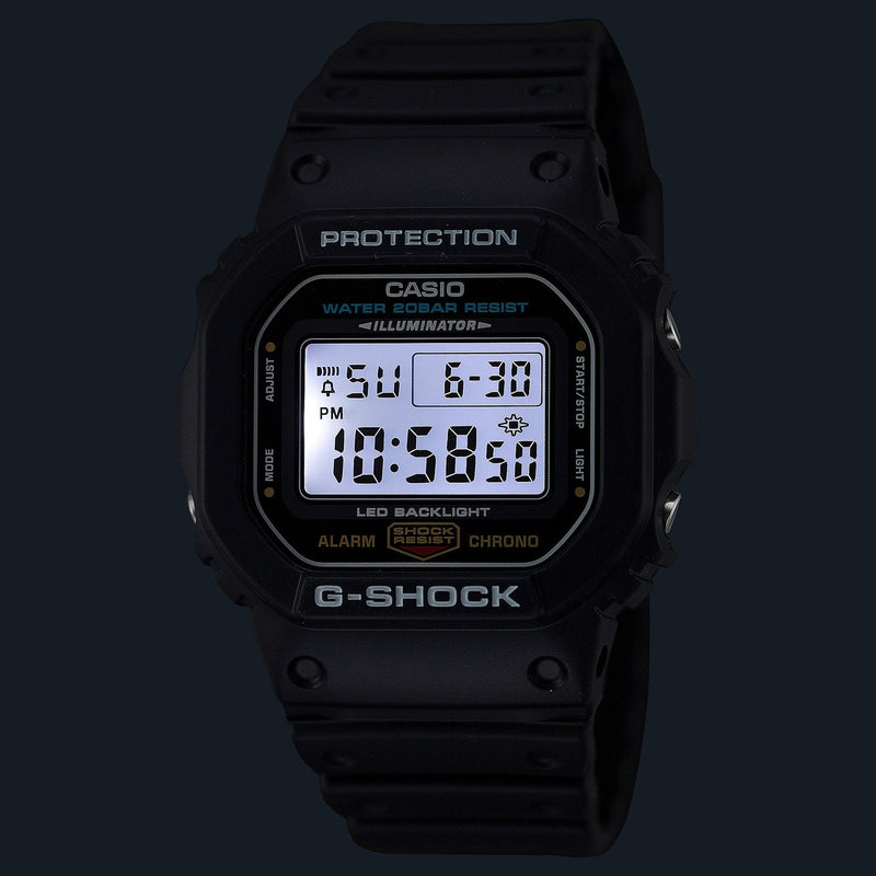 Black Casio G-Shock digital wristwatch with illuminated display showing time and date.