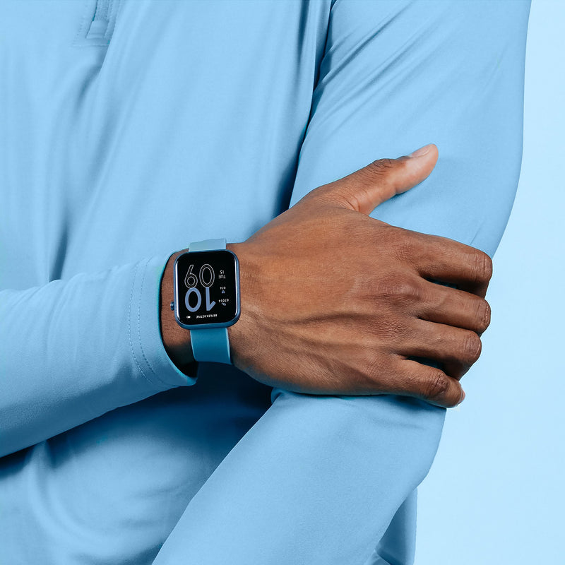 Smartwatch with a blue band displaying the time on a person’s wrist.