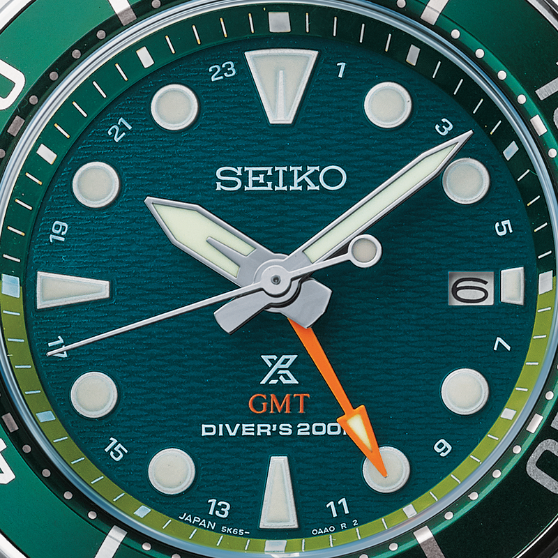 Green-faced Seiko diver’s watch with GMT function showing 10:10 time.