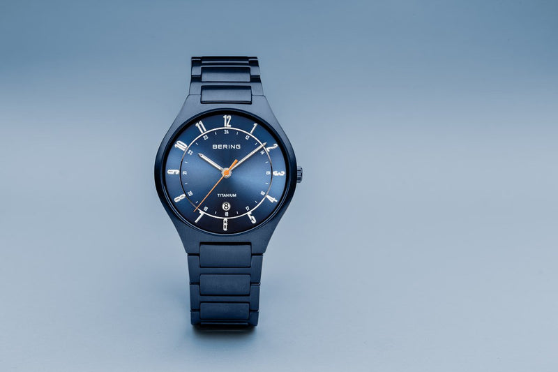 Sleek blue wristwatch with a metallic bracelet and minimalist dial design.