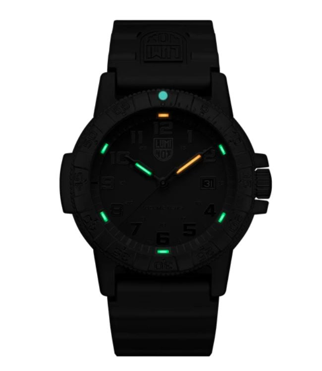 Black wristwatch with glowing green and orange markers on the dial.
