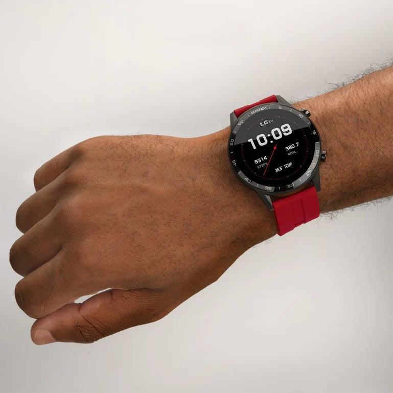 Smartwatch with a red strap worn on a wrist.