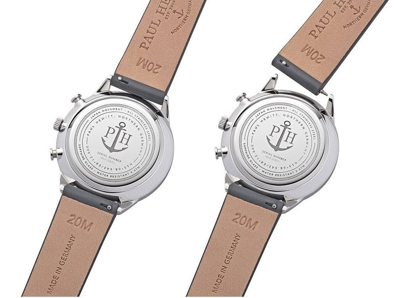 Two wristwatches with leather straps showing their casebacks, which feature an anchor logo.