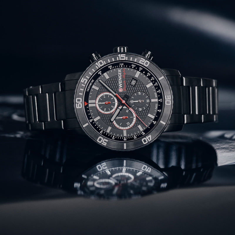 Sleek black chronograph wristwatch with red accents on a metal bracelet.