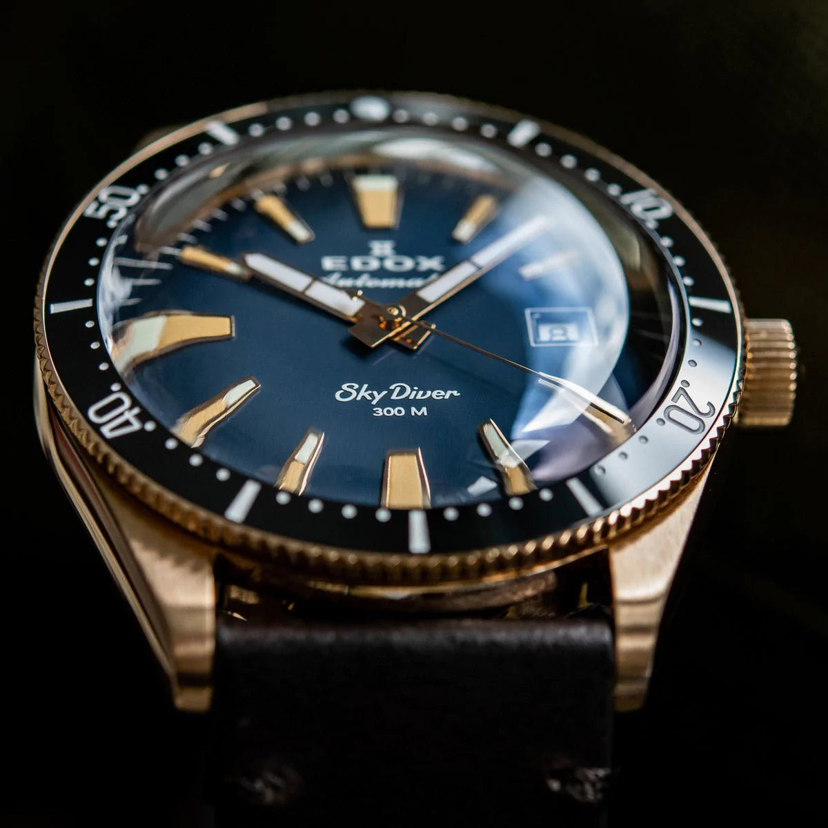 Luxury wristwatch with a blue dial and gold-toned case featuring ’Edox SkyDiver’ branding.