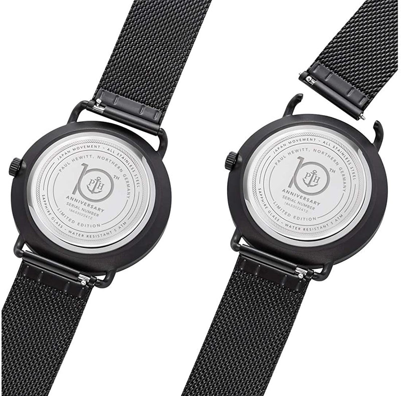 Two black wristwatches with mesh bands, showing their casebacks.