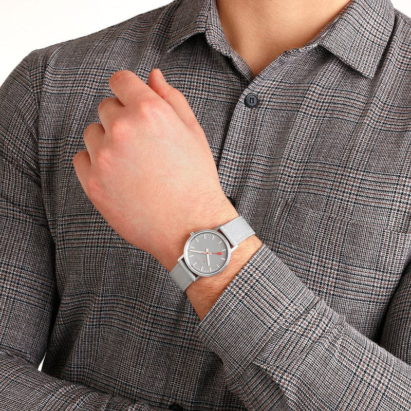 Wristwatch with a silver mesh band and gray circular face.