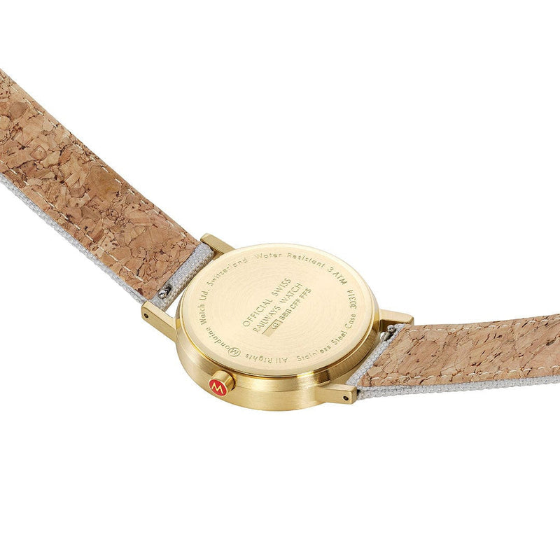 Wristwatch with a gold-colored case and cork-textured strap.