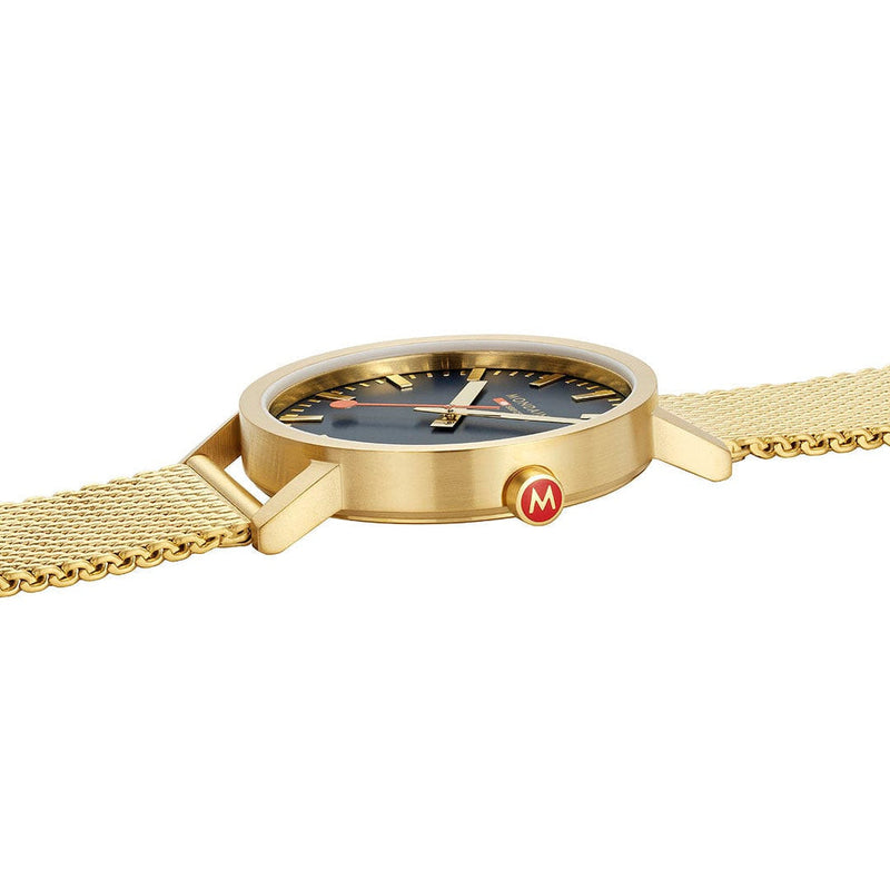 Gold-toned wristwatch with a navy blue dial and mesh band.