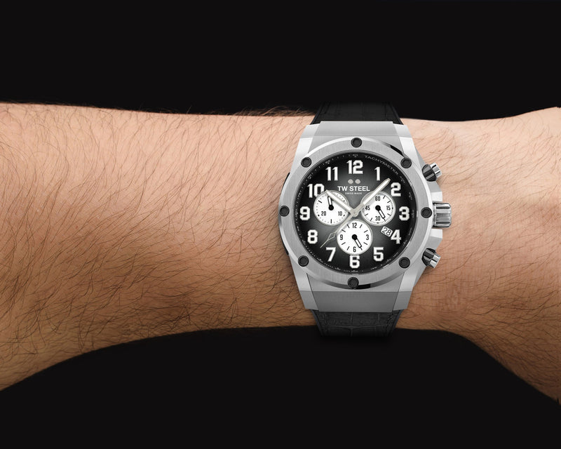 Luxury chronograph wristwatch with a silver case and black dial worn on a wrist.