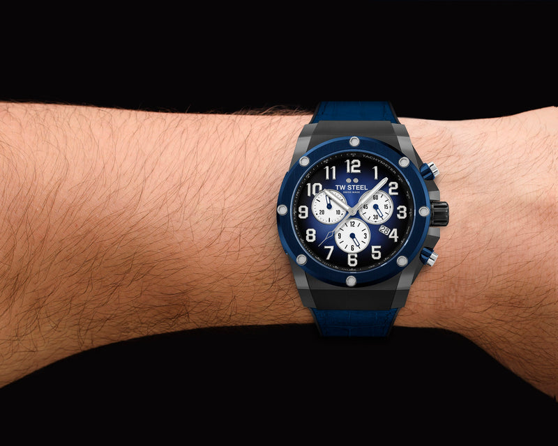 Blue and silver sports chronograph watch with a rubber strap worn on a wrist.