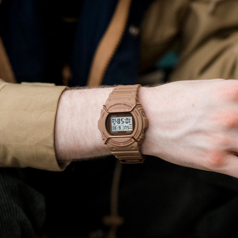 Gold-colored digital wristwatch with a square display.