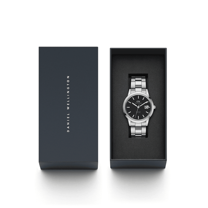 Stainless steel wristwatch with a black dial in an open presentation box.