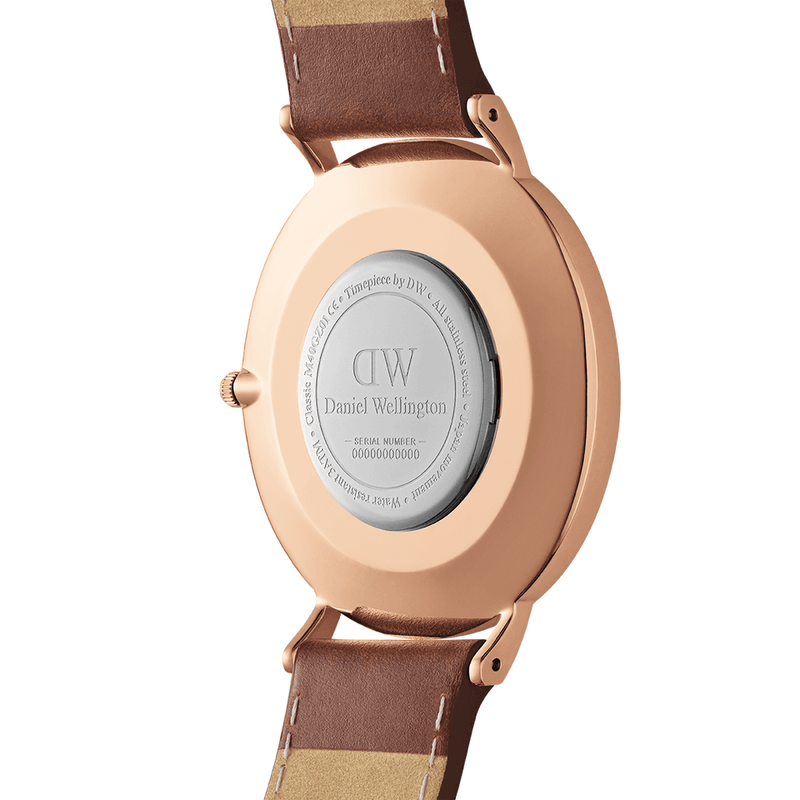 Rose gold wristwatch with a brown leather strap and a circular case back displaying ’DW Daniel Wellington’ engraving.