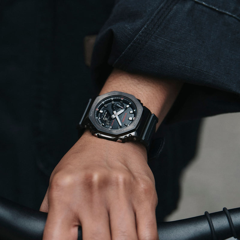 Sleek black wristwatch with an analog display on a person’s wrist.